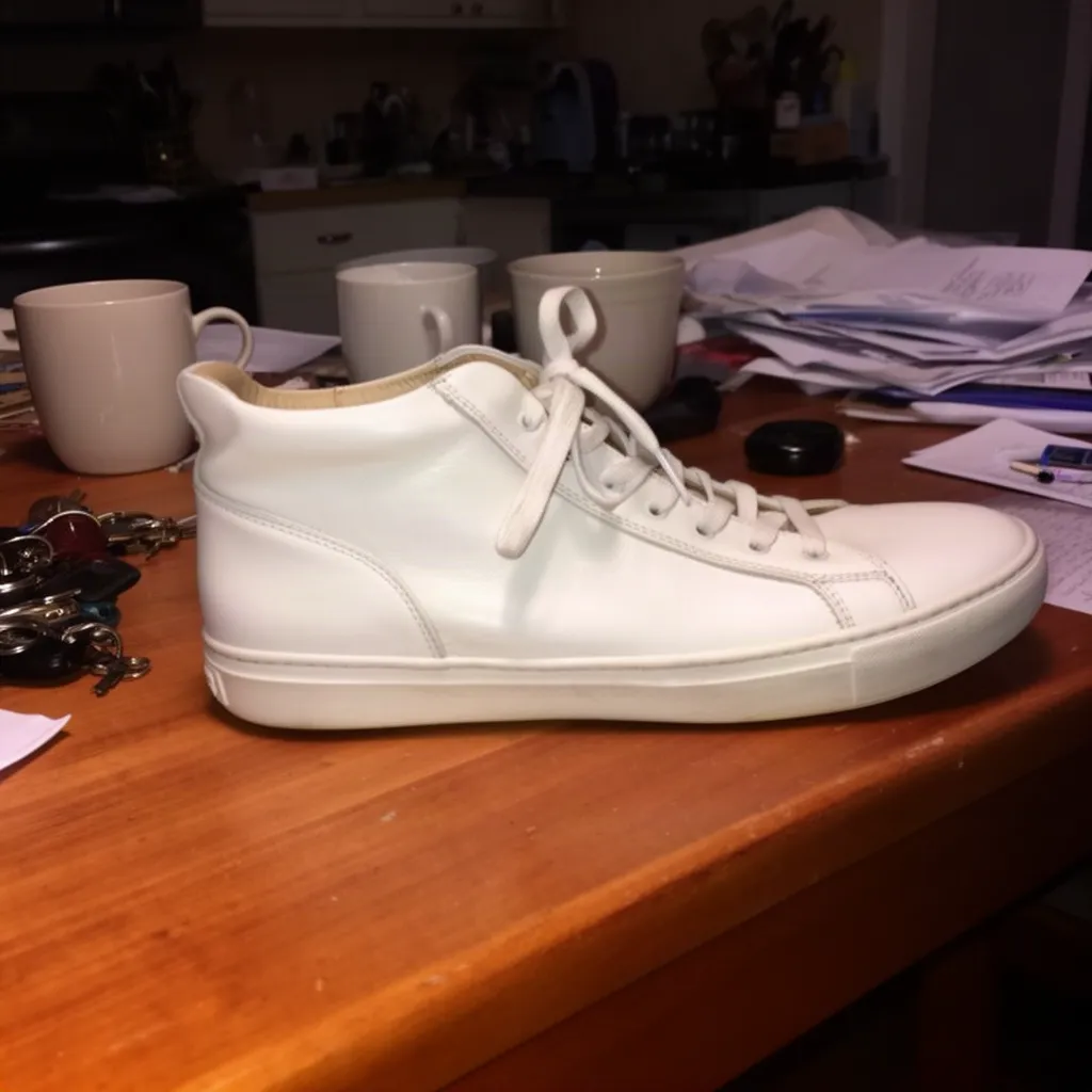 Original photo of a white leather sneaker on a cluttered kitchen table